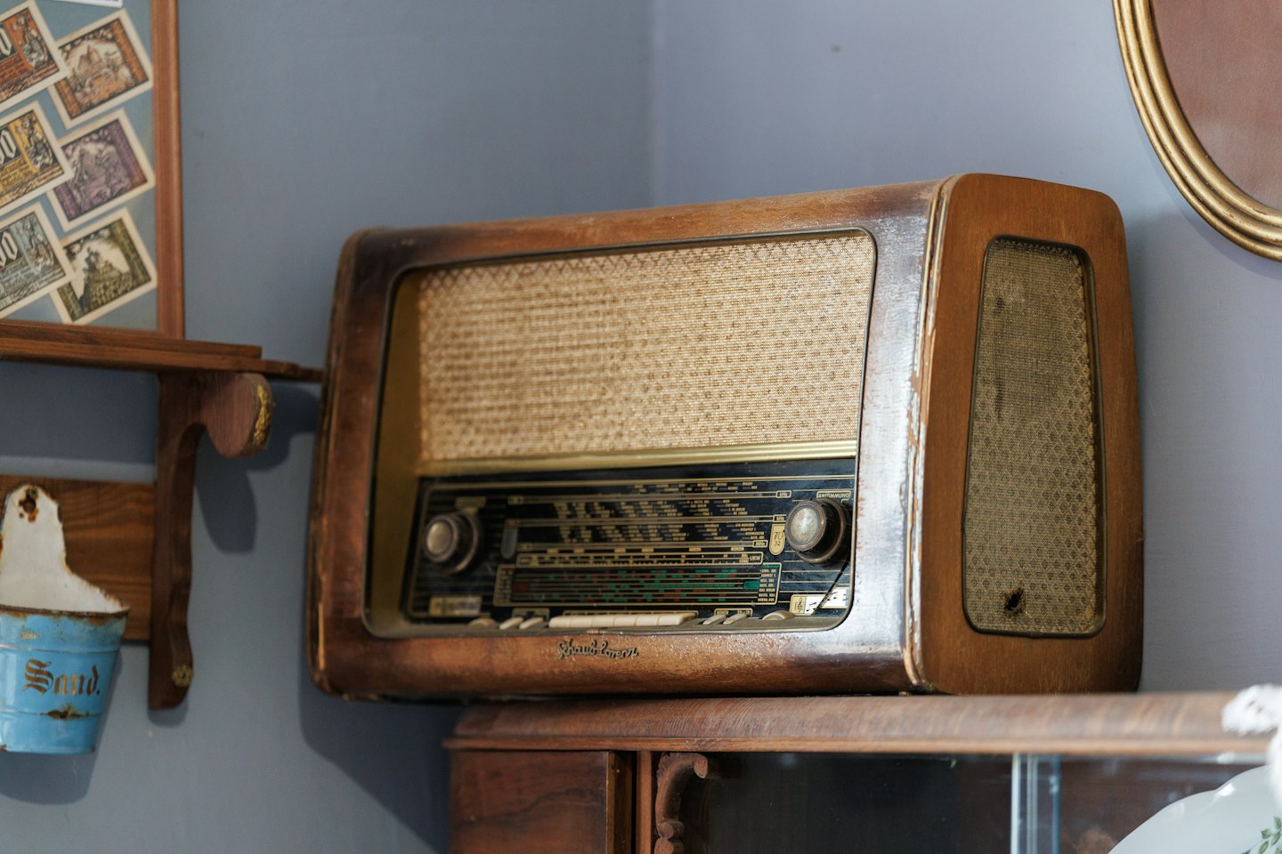 Stare radio SABA z pokrętłem strojenia na ciemnej drewnianej szafce.